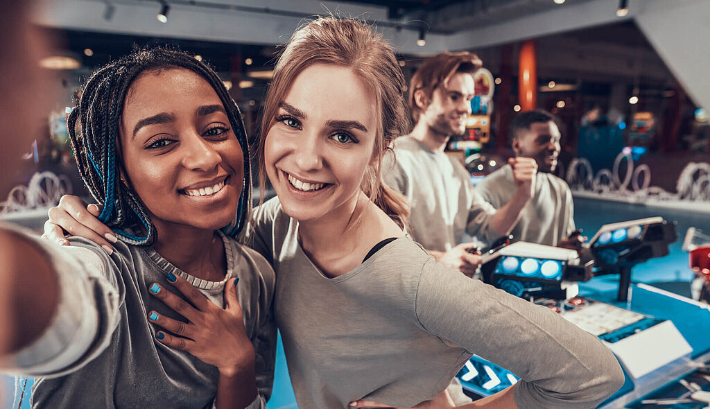 Zwei Mädchen machen ein Selfie auf einer Spielemesse.